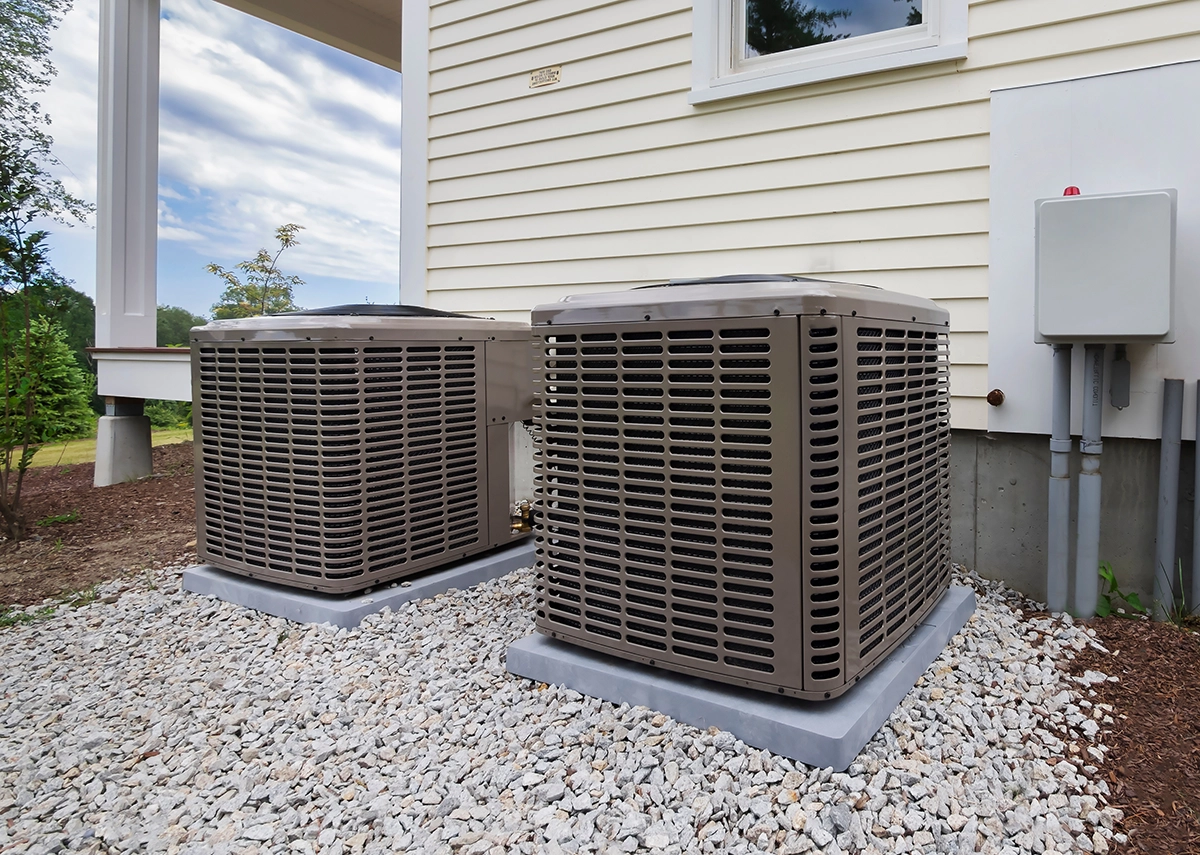 Residential outdoor AC condenser units connected to an HVAC system with components including the HVAC capacitor