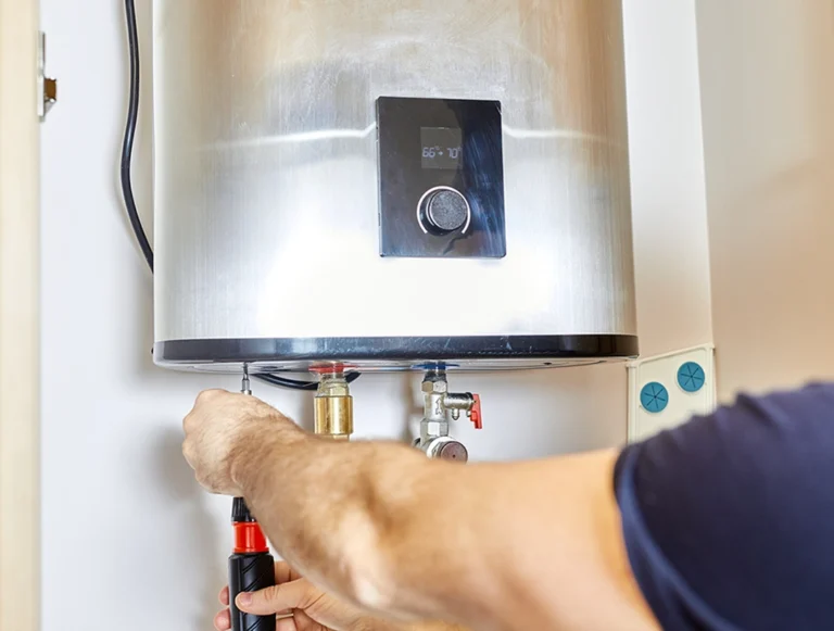 Emergency water heater repair same day: technician servicing a tankless water heater with digital temperature controls